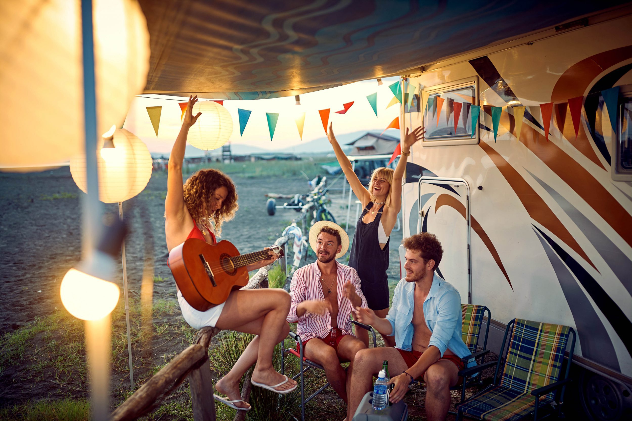 friends in front of camper rv cheering with drinks have party.